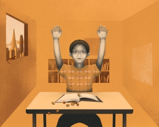 Boy at school classroom with hands up as he spill the acorns on his lesson book on the desk